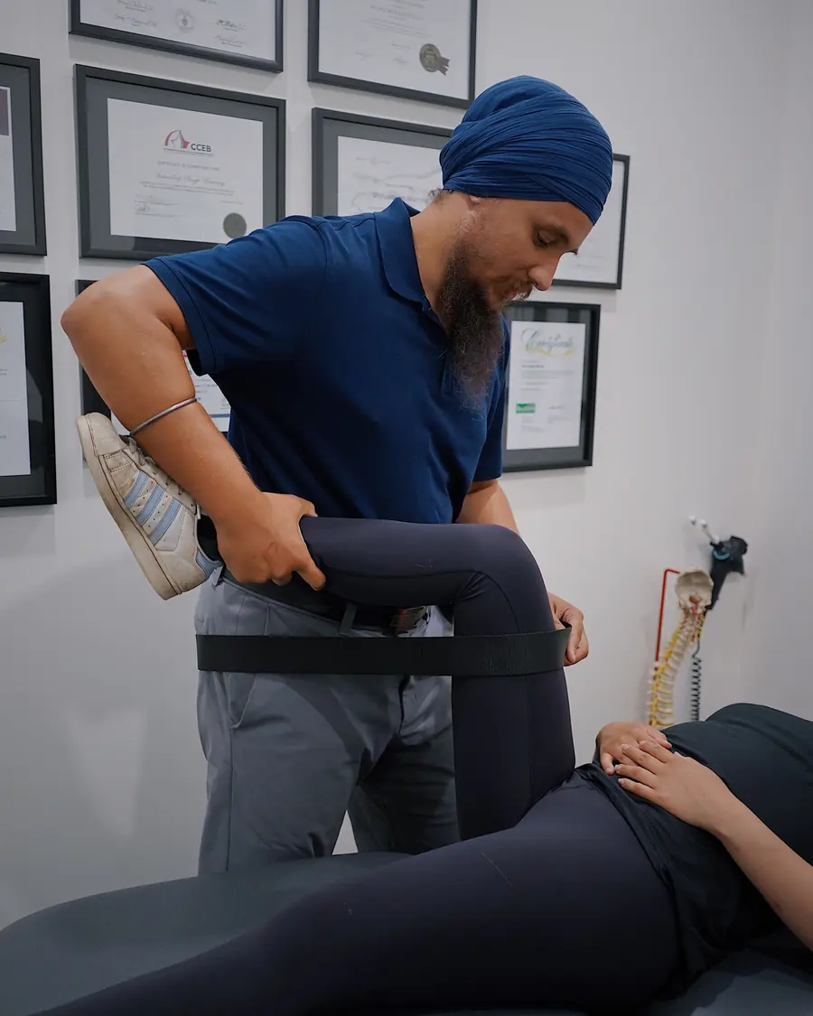 A physiotherapist treats a patient lying on a couch