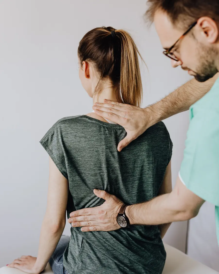 A physiotherapist’s hands on a patient’s lower back