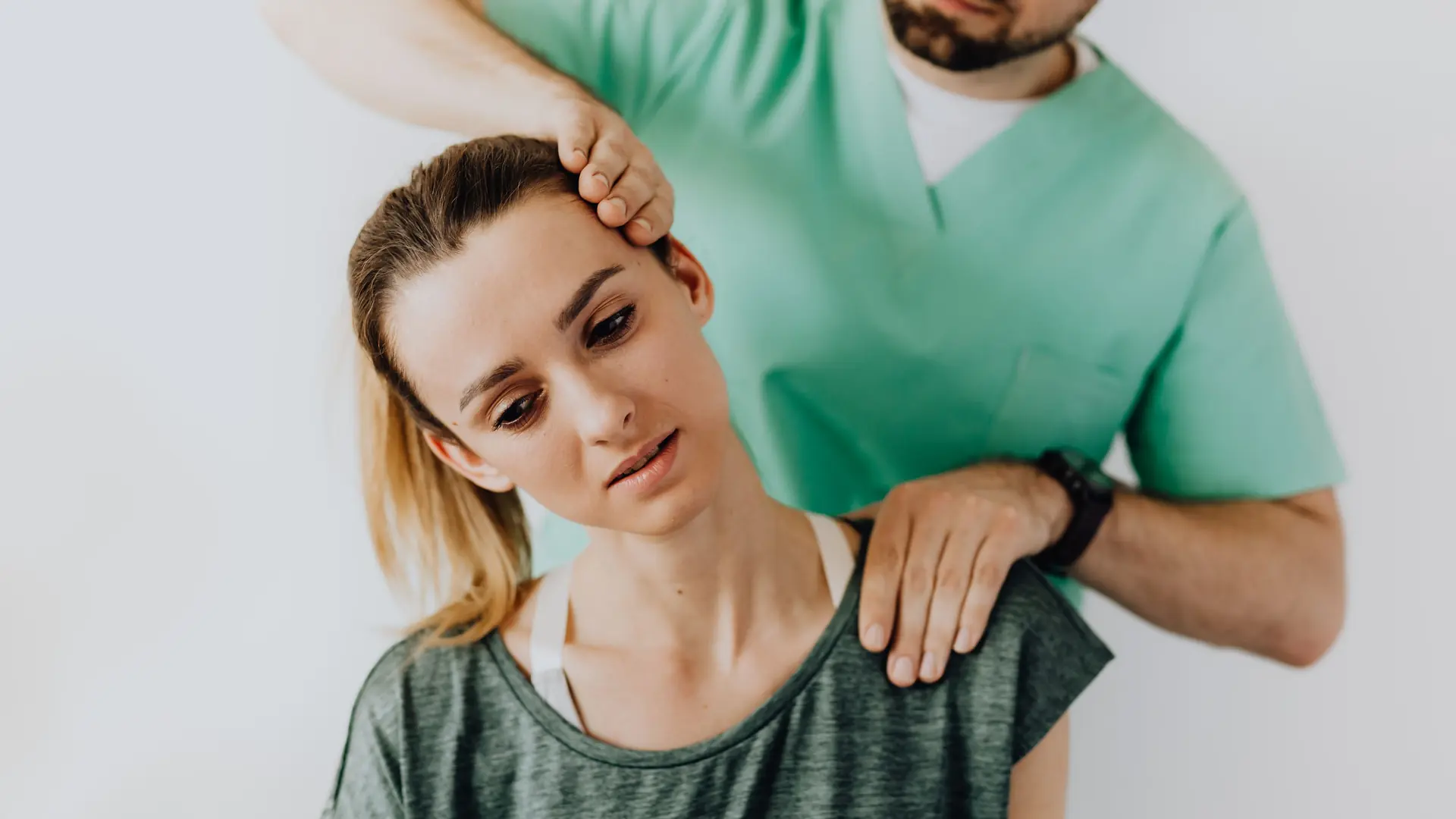 A physiotherapist examines a patient’s neck